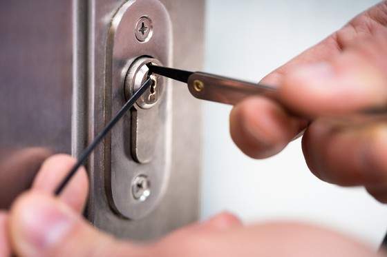 Gros plan sur un serrurier installant une nouvelle serrure de haute sécurité sur une porte, montrant la précision du travail, lumière naturelle.